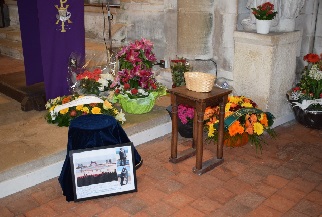 Parmi les corbeilles de fleurs, des photos de l’accolade du 70me anniversaire du Dbarquement